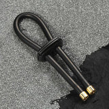 Black conductive rubber loop with brass accents on a textured gray surface