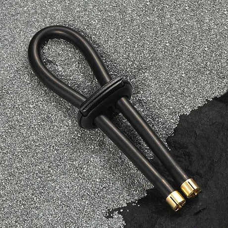 Black conductive rubber loop with brass accents on a textured gray surface