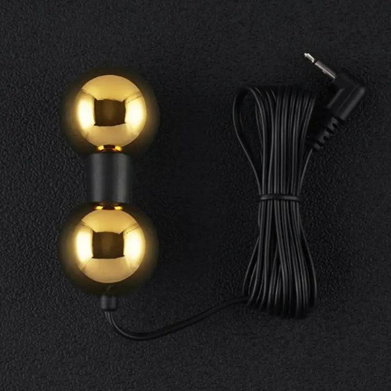 Gold dumbbell-shaped light bulb with a black cable on a dark background